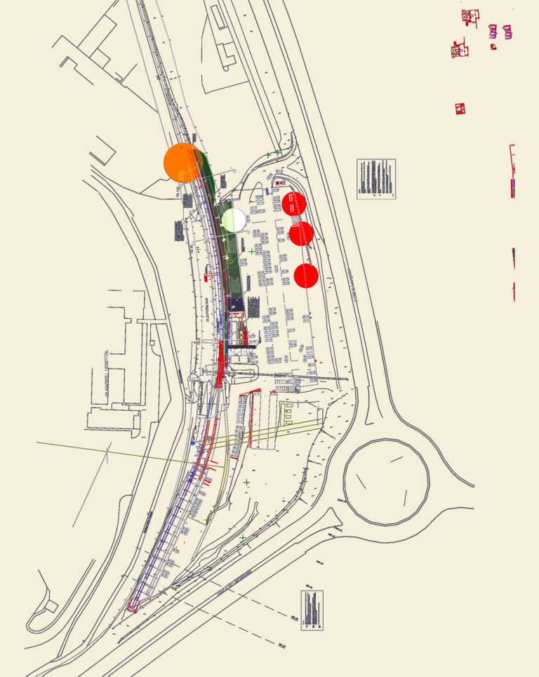 Site plan of a railway station showing platforms, car park, access roads, roundabout, and longitudinal track sections.