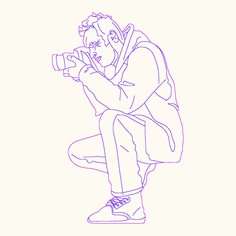 Side elevation of a photographer crouching with a camera